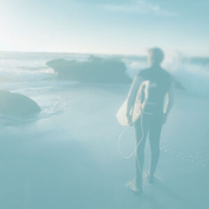 Surfer standing on the beach